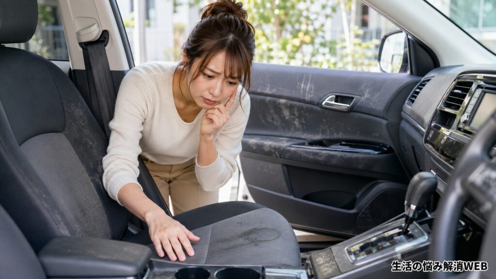 車内のシート汚れやドアパネルの黒ずみを確認する女性