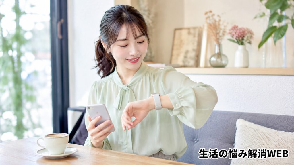 スマートウォッチに届いた通知を笑顔で確認する女性