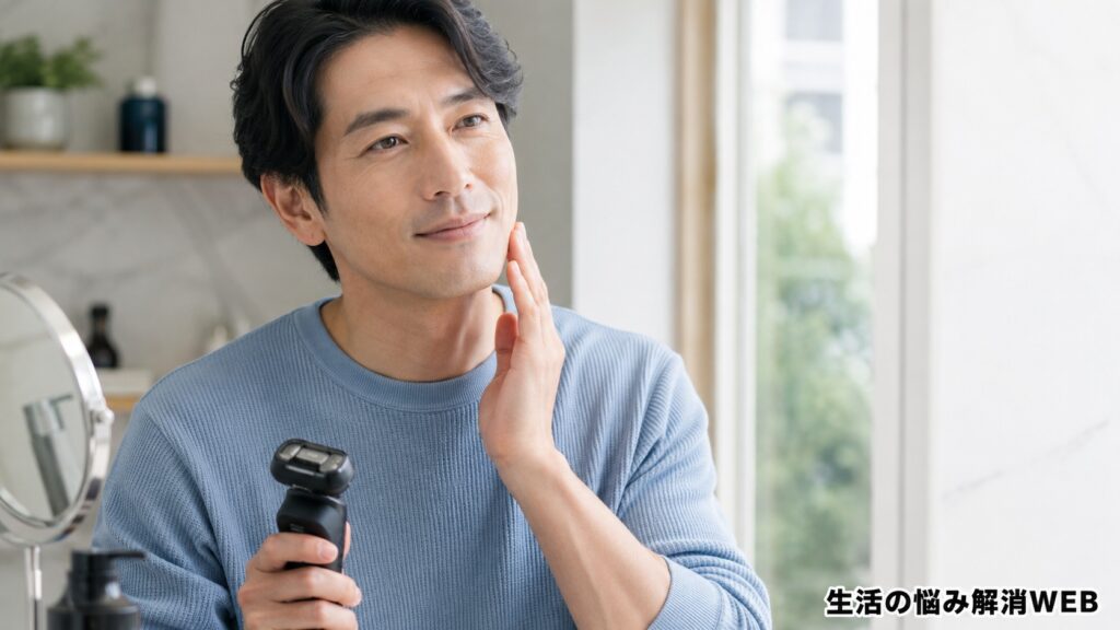 電動シェーバーの使用後に頬を触り、剃り心地を確認する清潔感のある日本人男性